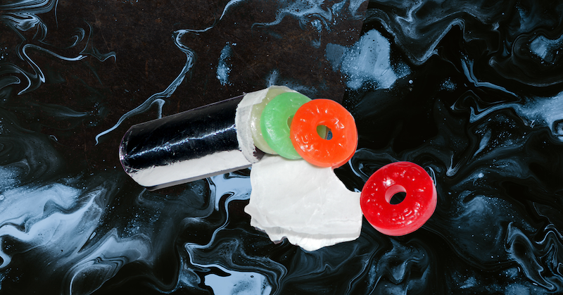 A partially unrolled tube of Live Savers against a black-and-white swirl background.