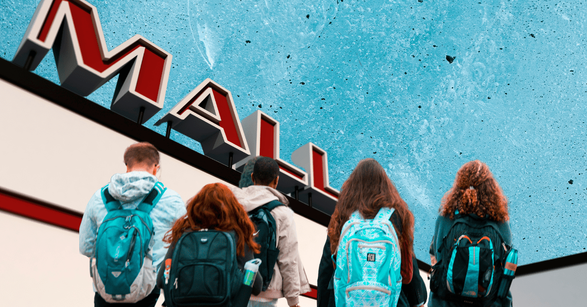 Students wearing backpacks walking towards a building with a sign that says mall.